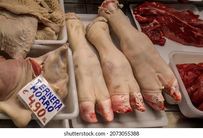 Raw pig trotters and veal snout for sale at a local butcher shop in Pamplona, Spain. Tag says veal snout and lists the price per kilo