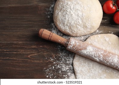 Raw Pizza Dough With Ingredients On Wooden Table