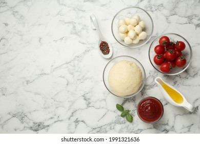 Raw Pizza Dough And Other Ingredients On White Marble Table, Flat Lay. Space For Text