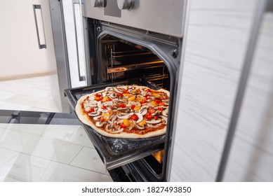 The Raw Pizza On A Baking Sheet In The Oven. Vegan Food.