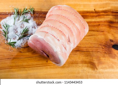 Raw Pork Leg Roast On Chopping Board With Herbs