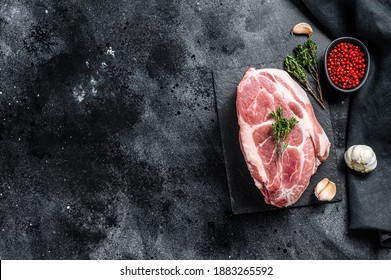 Raw pork neck meat. Chop steak. Black background. Top view. Copy space