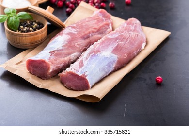 Raw pork tenderloin on craft paper ready to cook - Shutterstock ID 335715821