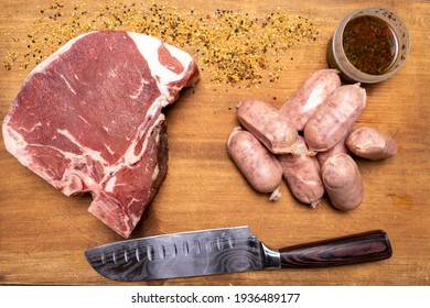 A Raw Porter House Steak With Argentinian Chorizos To Be Prepared With Chimichurri