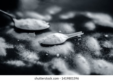 Raw Powdered Baking Soda In A Antique Spoon On Wooden Surface Along With Some More In A Plastic Spoon.Horizontal Shot.