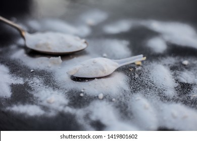 Raw Powdered Baking Soda In A Antique Spoon On Wooden Surface Along With Some More In A Plastic Spoon.Horizontal Shot.