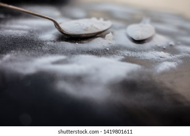 Raw Powdered Baking Soda In A Antique Spoon On Wooden Surface Along With Some More In A Plastic Spoon.Horizontal Shot.