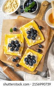 Raw puff pastry with cheese cream and blueberries. The process of making delicious sweet buns or mini pies	