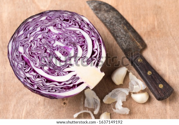 raw purple Lombard and divided in half on a wooden\
board on the table