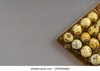 Raw Quail Eggs On A Gray Background. Brown Plastic Egg Tray. Close-up, Selective Focus.