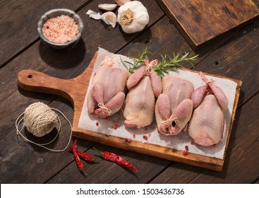Raw quail preparation on wooden table 