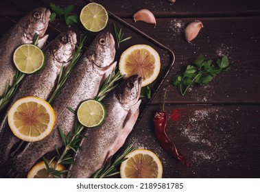 Raw Rainbow Trout, With Lemon And Herbs, On A Wooden Table, No People,