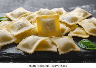 Raw Ravioli with Flour and Basil on Dark Background, Fresh Italian Ravioli - Powered by Shutterstock