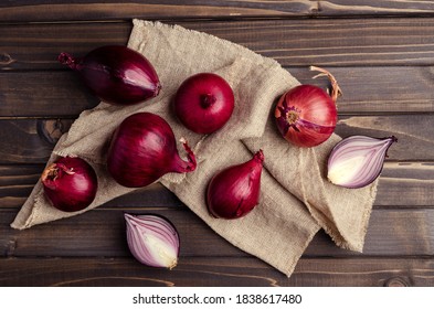 Raw Red Onion On Textile Burlap On A Dark Wooden Background. Selective Focus.