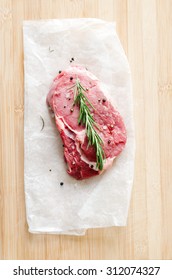 Raw Rib Eye Steak On Wooden Board, Overhead Perspective