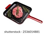 Raw Rib eye steak in a skillet, marbled prime beef meat isolated on white background.