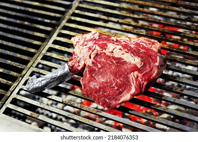 Raw Ribeye Steak Bone In Cooking On The Grill