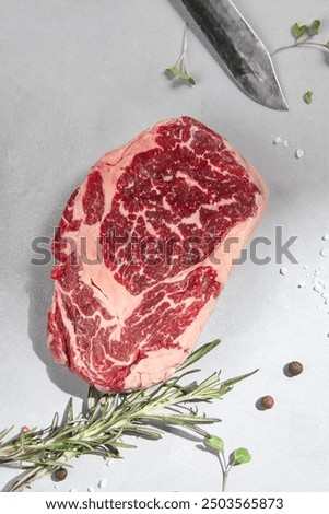 Raw Ribeye Steak on Gray Background Marbled Beef Cut for Gourmet Cooking.