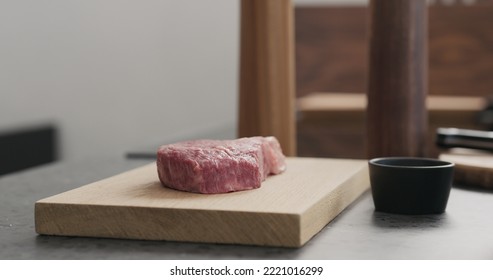 Raw Ribeye Steak On Oak Wood Board