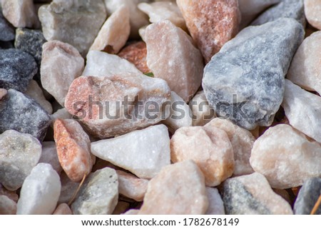 Raw rocks and minerals as natural stones background with crushed and rough material at a rough coast or rocky beach show nuggets and sandstones in harmonic pastel colors