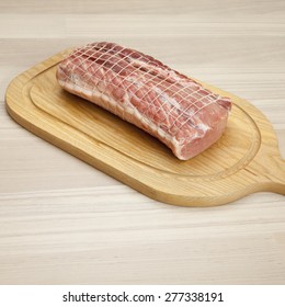 Raw Rolled Pork Roast On Chopping Board