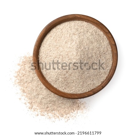 Raw rye flour in the wooden bowl, isolated on white background, top view.