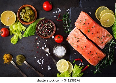 Raw Salmon Fillet And Ingredients For Cooking On A Dark Background In A Rustic Style. Top View