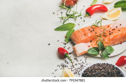 Raw Salmon Fish Fillet Steaks With Vegetables, Greens, Rice, Spices And Lemon Over Light Grey Marble Background, Copy Space. Clean Eating, Alkaline Diet, Dieting, Power Boosting, Weight Loss Concept