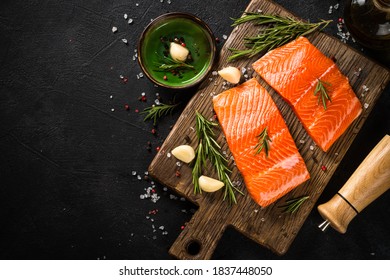 Raw Salmon fish, fresh salmon fillet at cutting board with ingredients for cooking. Top view with copy space.