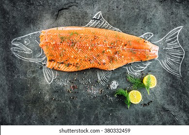 Raw Salmon Fish Steak With Ingredients Like Lemon, Pepper, Sea Salt And Dill On Black Board, Sketched Image With Chalk Of Salmon Fish With Steak