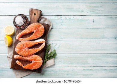 Raw Salmon Fish Steaks With Spices Cooking On Cutting Board. Top View With Space For Your Text