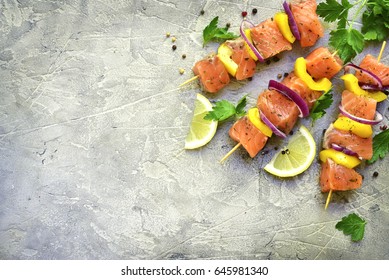 Raw salmon kebab on a grey slate,stone or concrete background.Top view with copy space.