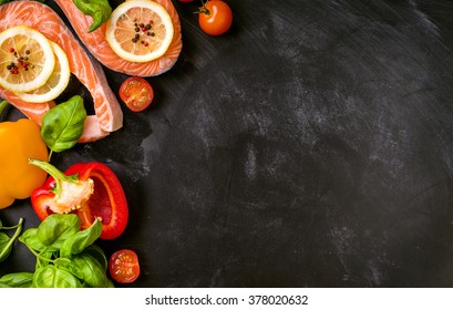 Raw salmon steaks and fresh ingredients for cooking on a dark background. Banner, frame, menu. Healthy and diet food concept. Space for text. Top view - Powered by Shutterstock