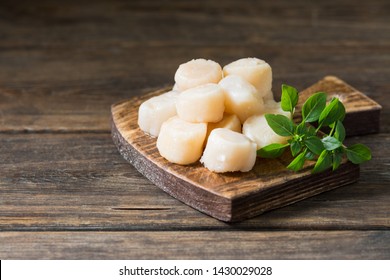 Raw scallops on wooden Board on wooden background