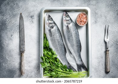 Raw Sea Bass Or Seabass Fish In A Baking Dish. White Background. Top View.