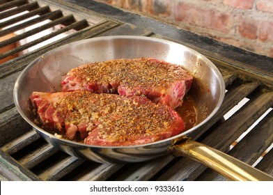 Raw Seasoned Rib-eye In A Stainless Steel Frying Pan Waiting To Be Cooked