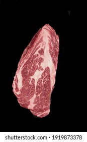 Raw Sirloin Beef Steak, Overhead View. Single Raw Striploin Steak From Marbled Beef Isolated On Black Background. Black Angus Beefsteak Meat. Raw Tenderloin Marble Steak. Uncooked Prime Beef Steak.