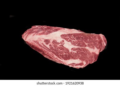 Raw Sirloin Beef Steak, Overhead View. Single Raw Striploin Steak From Marbled Beef Isolated On Black Background. Black Angus Beefsteak Meat. Raw Tenderloin Marble Steak. Uncooked Prime Beef Steak.