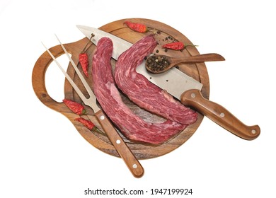 Raw Skirt Steak Or Tenderloin Beef Steak, Knife And Fork On Round Cutting Board Isolated On White Background, Overhead View. Uncooked Machete Steak Or Bavet Steak On White Background.