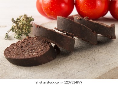 Raw Sliced Irish Black Pudding On A Wooden Board