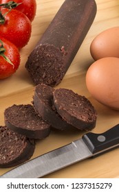 Raw Sliced Irish Black Pudding On A Wooden Board