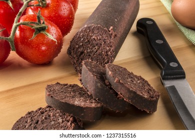 Raw Sliced Irish Black Pudding On A Wooden Board