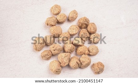 Raw soya chunks on dark background. Healthy, nutritious soybean meat, chunks isolated.Vegan food concept.