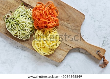 Raw spaghetti from fresh vegetables.  Zucchini,  carrot and potato pasta. Flat layot, copy space