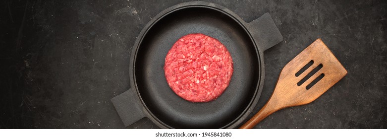 Raw Steak Burgers Cutlets On Grill Pan. Burgers Patties From Marbled Beef Meat In Frying Pan On Black Background, Overhead View. Griddle Pap And Ground Beef Meat Patties For Grilling, Top View.