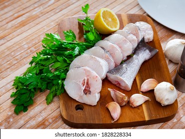 Raw Steaks Of Hake With Lemon And Greens Ready For Cooking. High Quality Photo