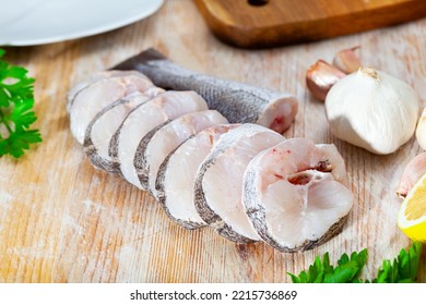 Raw Steaks Of Hake With Lemon And Greens Ready For Cooking On The Wooden Surface