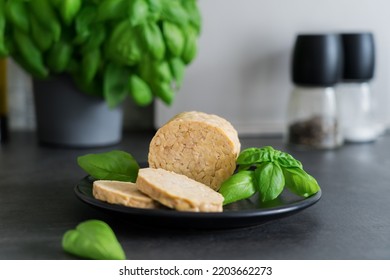 Raw Tempeh Or Tempe, Made Of Fermented Soybean Seeds On Kitchen Table. Tempeh Slices On Plate With Herbs. Soya Protein. Plant Based Meat Concept. Healthy Eating. Go Vegan. Selective Focus, Copy Space