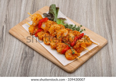 Raw tiger shrimps skewer with spices on the wood background