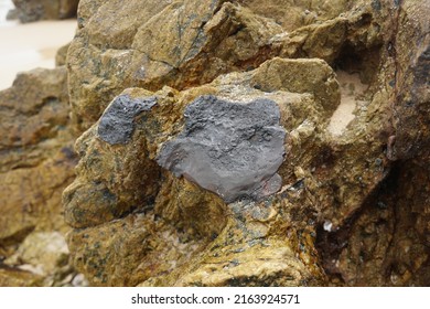 Raw Tin Metal Ore Stuck On Rock.